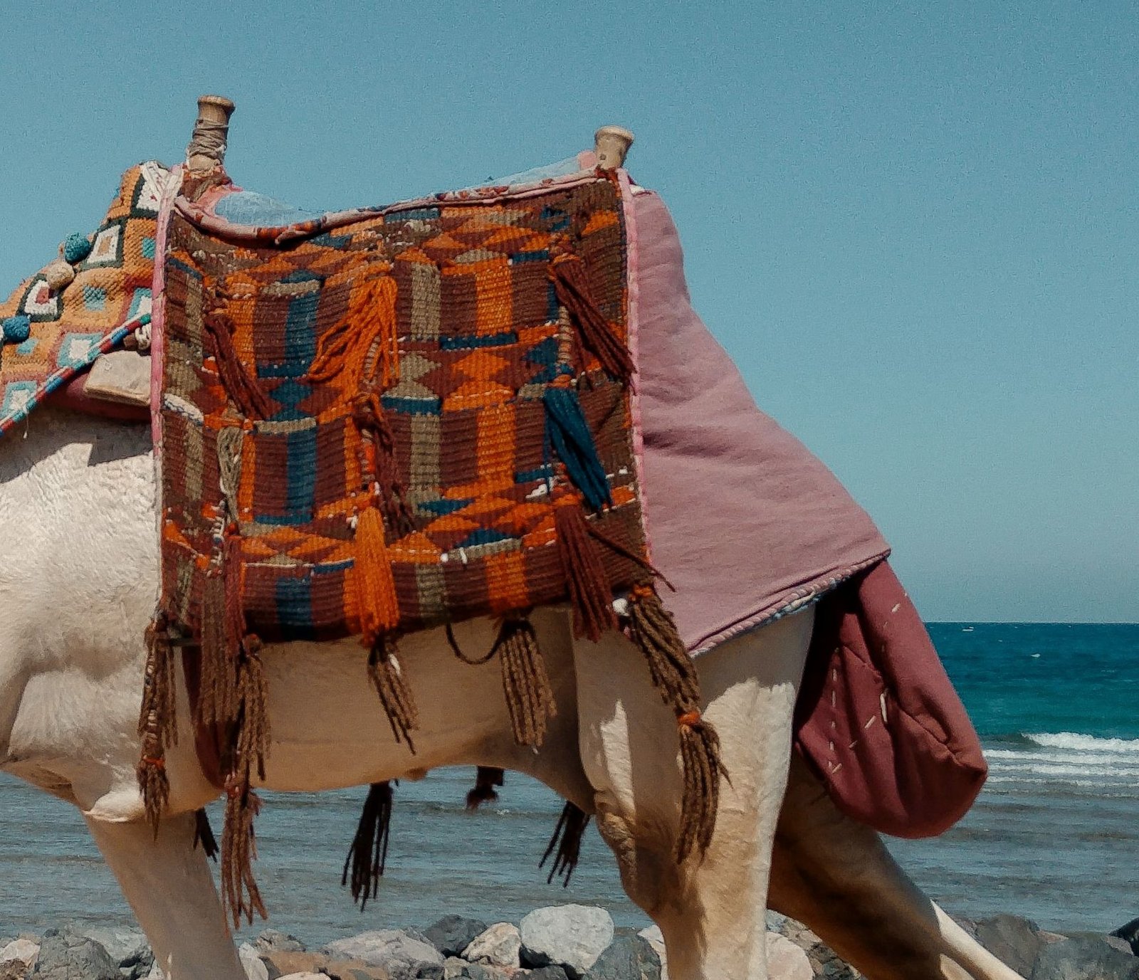 A handwoven textile with a tasselled fringe, faded by the sun and still in use