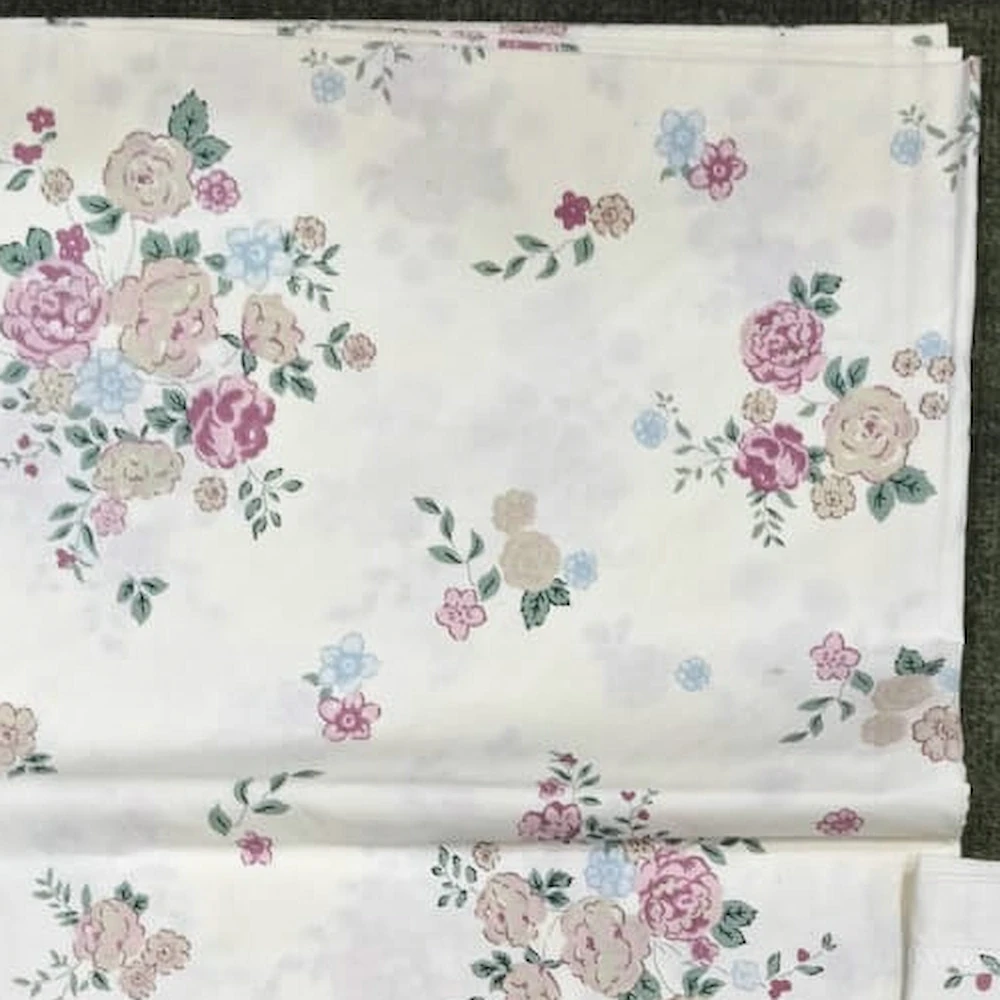 Close-up of The Chintz: small pink and grey roses scattered on white.