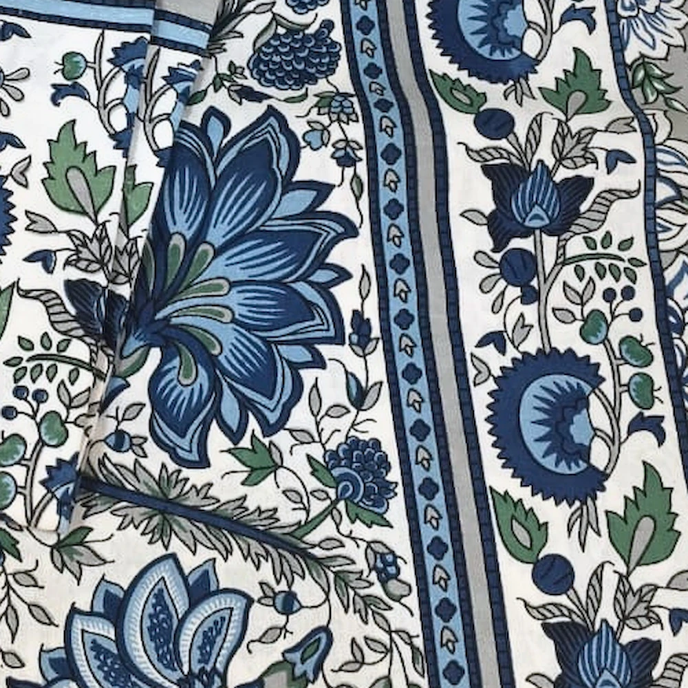 Close-up of The Cornflower: dense indigo and blue flowers on white with a striped blue border.