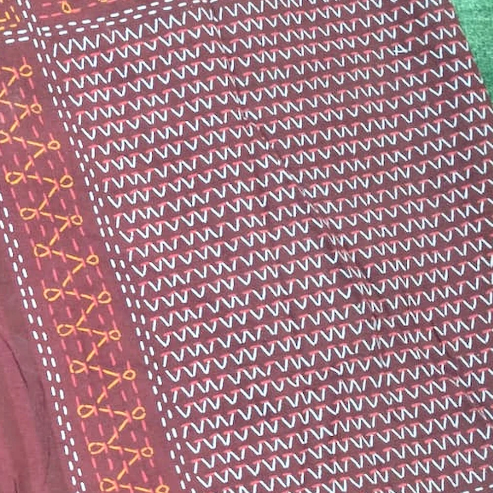 Close-up of The Crimson: deep maroon with fine geometric panels in rose and cream.