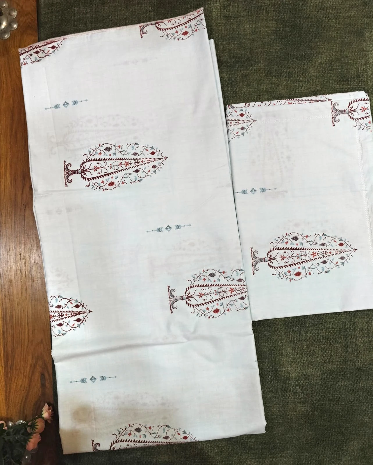 The Cypress: tall red tree motifs on white and cream, folded.