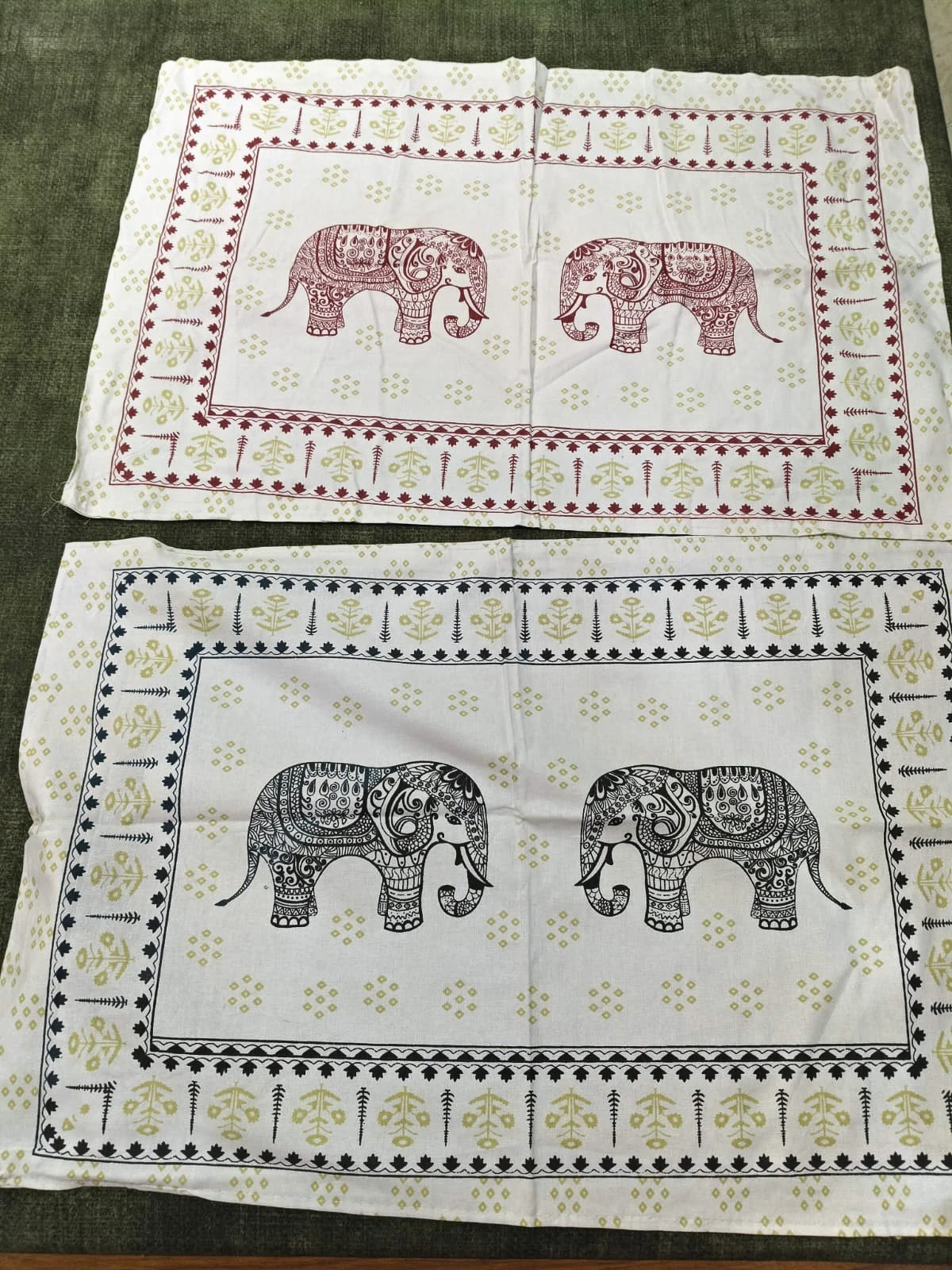 The Elephant Parade: rows of small elephants in rose and grey on white, with elephant-panel pillowcases, folded.