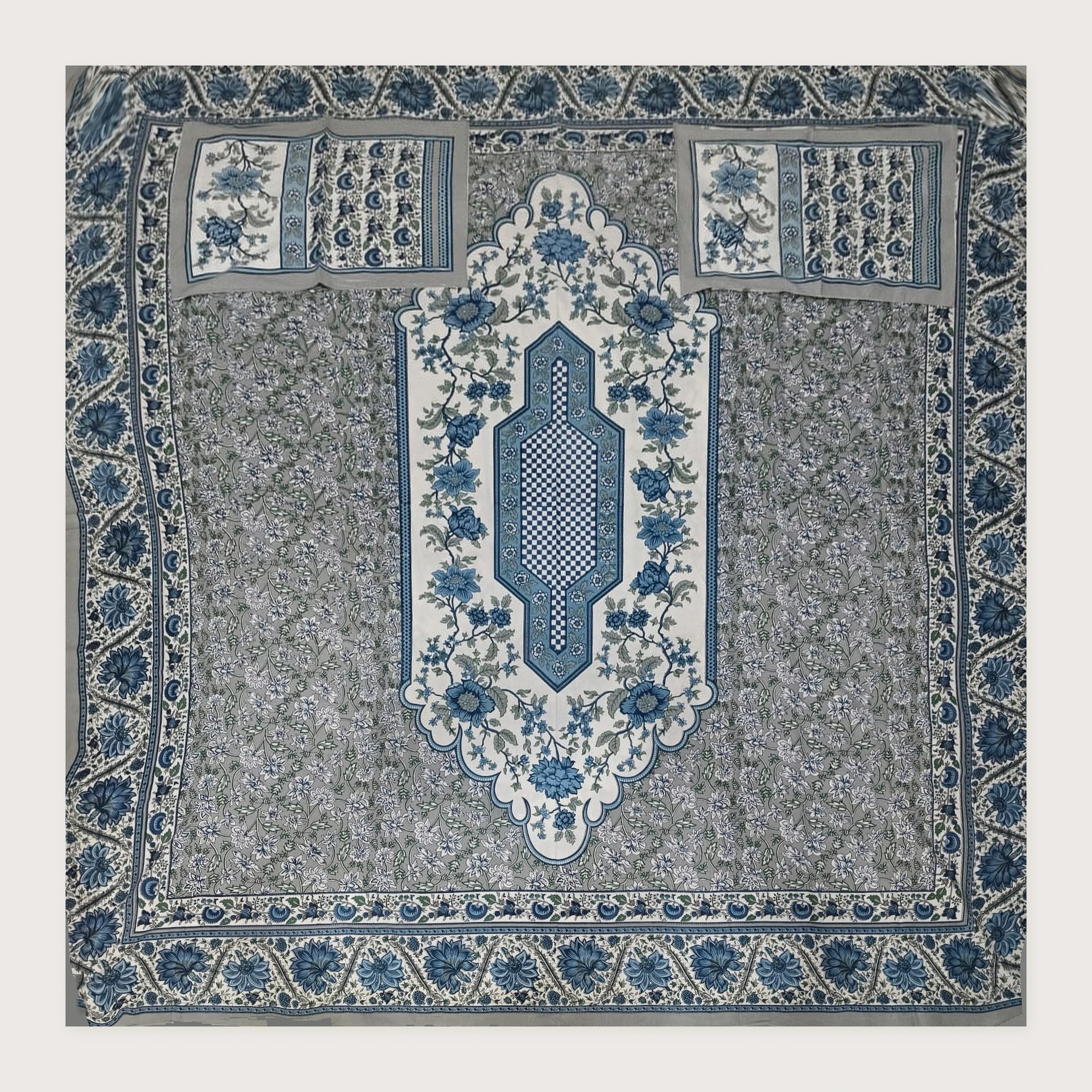 The Fernleaf: blue-grey floral cloth with a long ivory centre panel and two matching pillowcases, laid flat, seen from above.