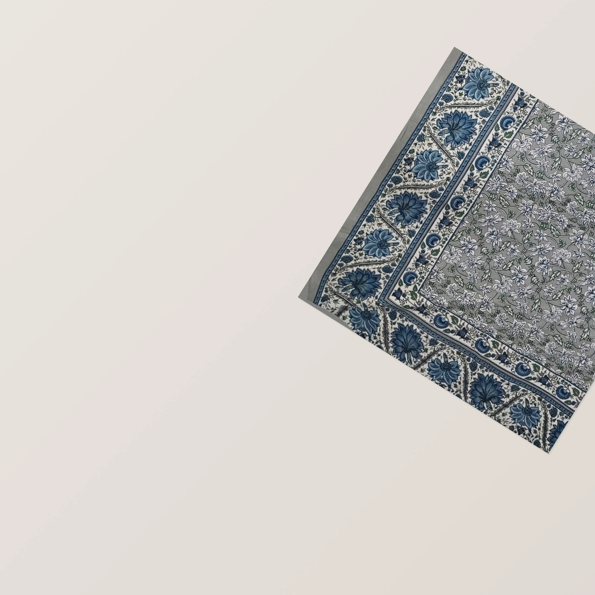 The Fernleaf: blue-grey floral cloth with a long ivory centre panel and two matching pillowcases, corner and hem, laid flat.