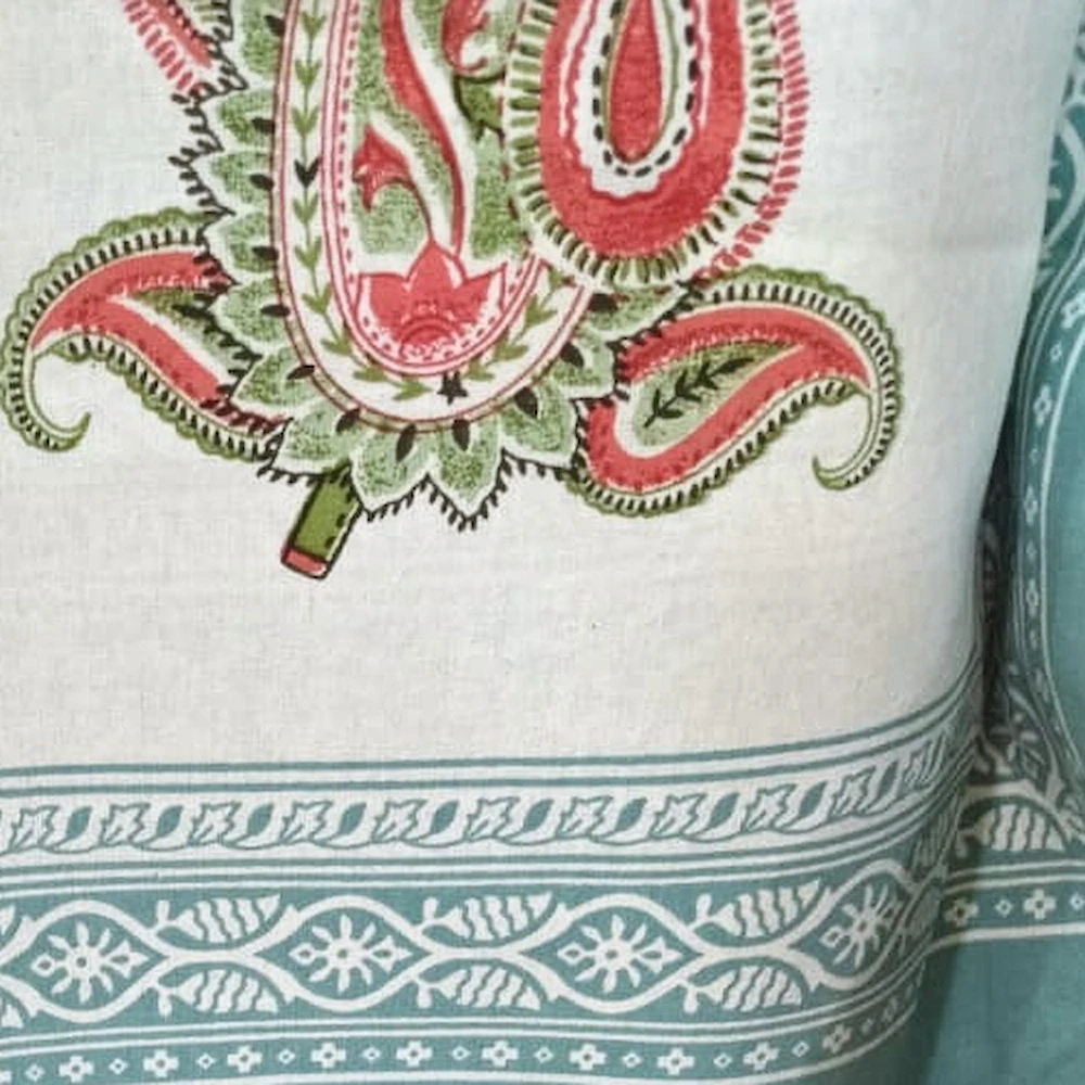 Close-up of The Paisley, white: rose and green paisley on white cotton with a teal border.