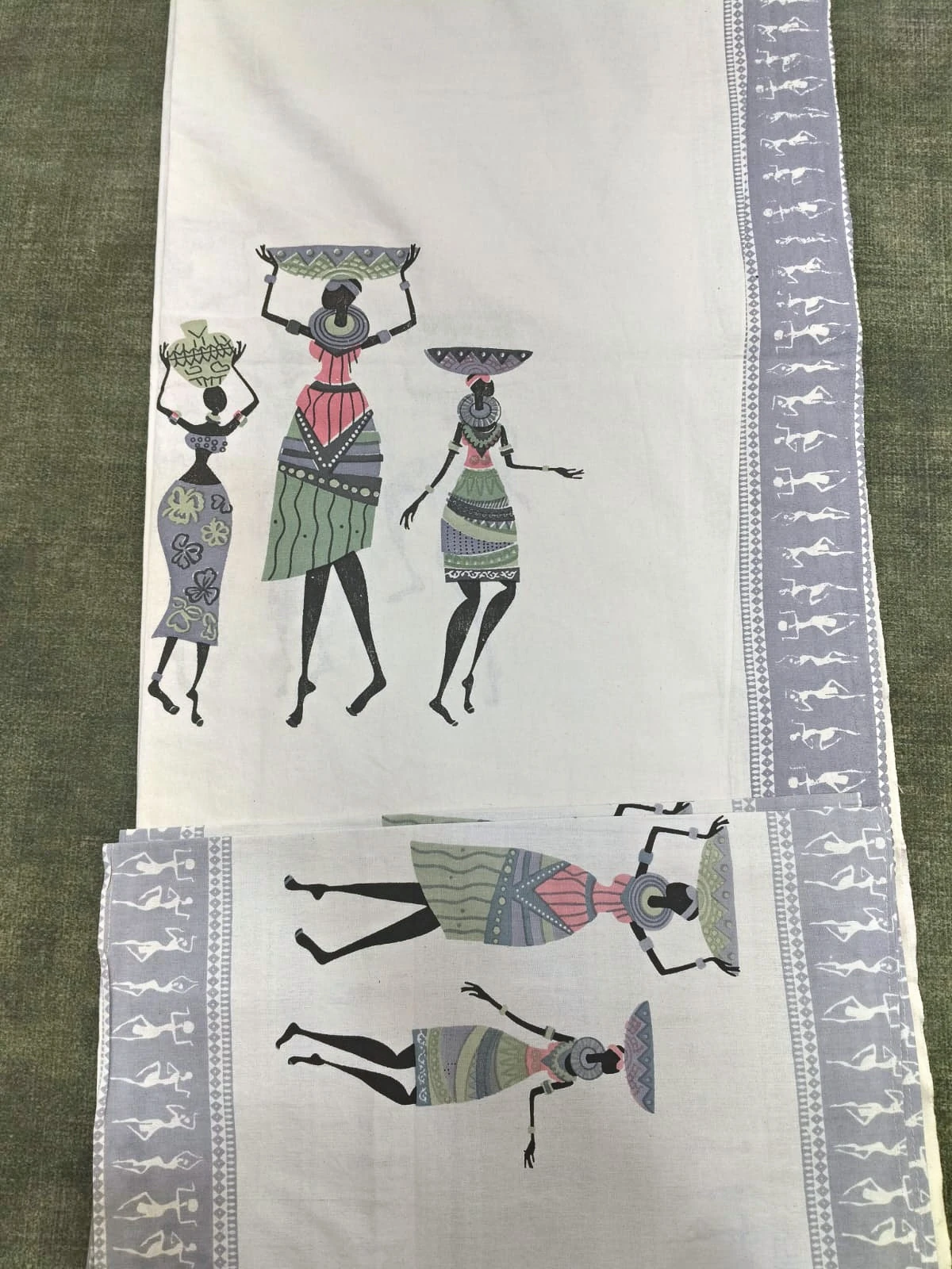 The Procession: rows of drawn figures carrying pots, in grey, green and black on white, folded.